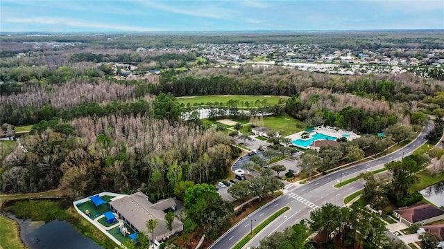 birds eye view of property featuring a water view and a wooded view