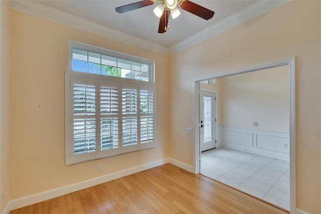 spare room with a healthy amount of sunlight, crown molding, and wood finished floors