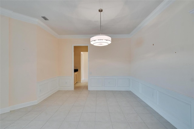 spare room with light tile patterned floors, a decorative wall, visible vents, and crown molding