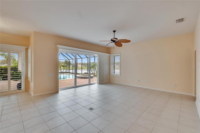 unfurnished room with a healthy amount of sunlight, light tile patterned floors, ceiling fan, and visible vents