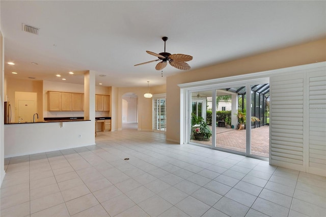 unfurnished living room with light tile patterned floors, visible vents, arched walkways, a ceiling fan, and recessed lighting