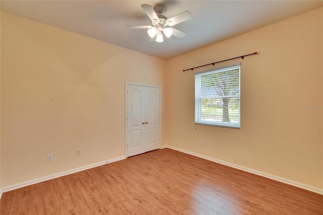 spare room featuring wood finished floors, a ceiling fan, and baseboards