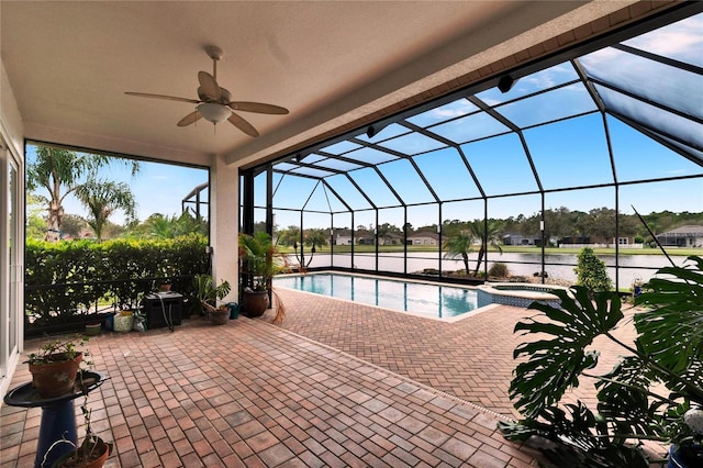 view of swimming pool with a ceiling fan, a pool with connected hot tub, glass enclosure, and a patio