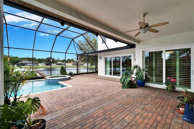 view of swimming pool featuring a pool with connected hot tub, a patio area, glass enclosure, and ceiling fan