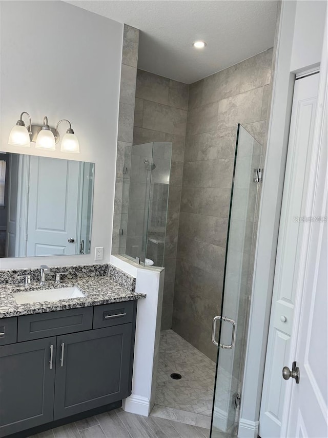 bathroom with vanity and a shower with shower door