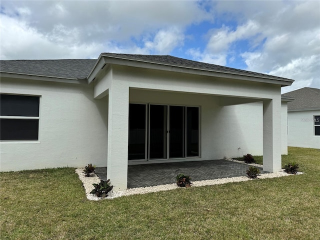 back of property with a patio area and a lawn