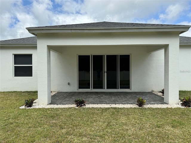 rear view of house with a patio and a yard