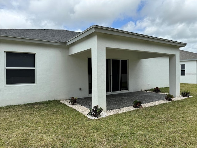 back of property featuring a patio area and a yard