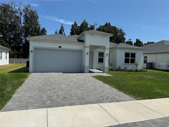 ranch-style home featuring cooling unit, a garage, and a front lawn