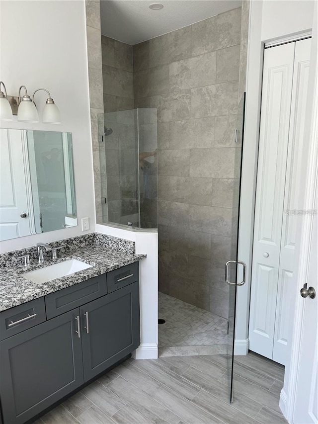 bathroom with walk in shower and vanity