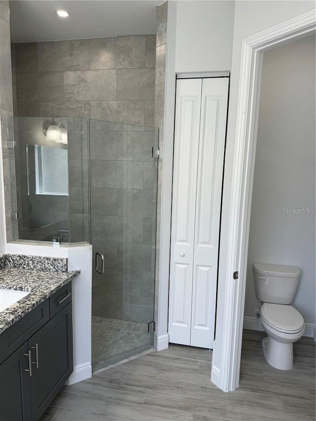 bathroom featuring vanity, toilet, and walk in shower