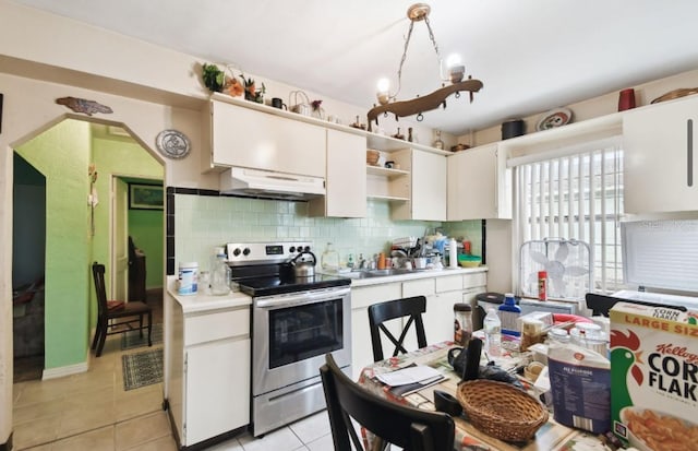 kitchen featuring backsplash, white cabinetry, light tile patterned floors, and stainless steel electric range