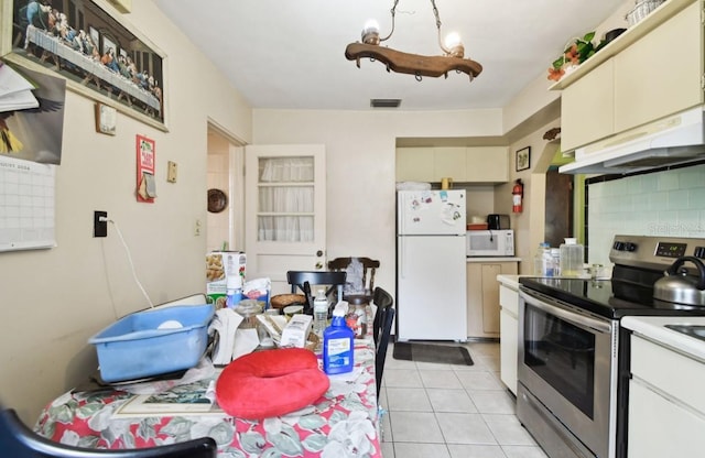 kitchen featuring white appliances, tasteful backsplash, cream cabinets, and light tile patterned flooring