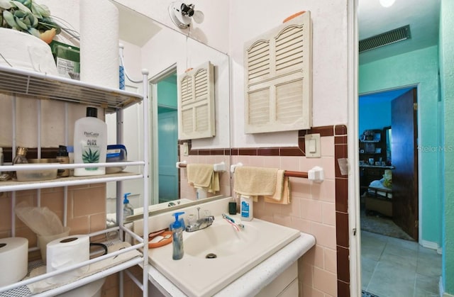 bathroom with sink and tile walls