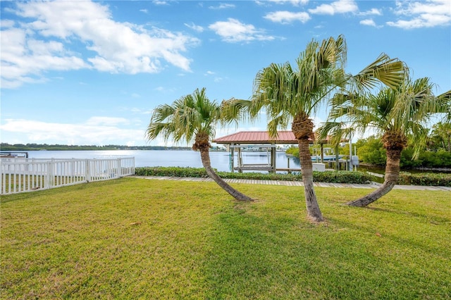 view of yard featuring a gazebo, a water view, and fence