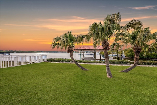 yard at dusk featuring a gazebo and a water view