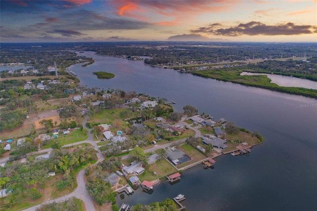 aerial view at dusk with a residential view and a water view