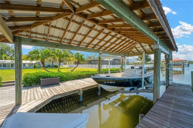 dock area featuring boat lift, a yard, and a water view