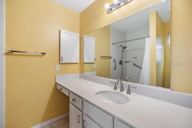 bathroom with tile patterned flooring, vanity, a textured ceiling, and walk in shower