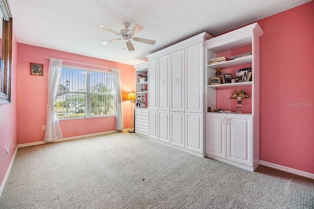 unfurnished bedroom featuring light colored carpet, a textured ceiling, and ceiling fan