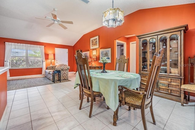 tiled dining space with lofted ceiling and ceiling fan