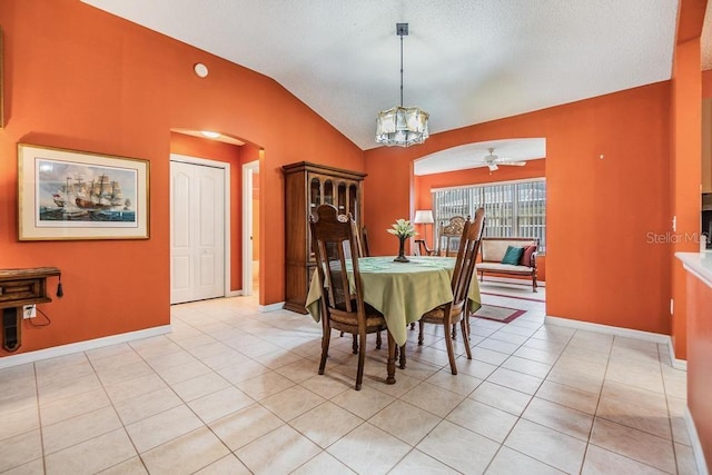 dining room featuring lofted ceiling, light tile patterned floors, and ceiling fan with notable chandelier