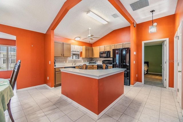 kitchen with a kitchen island, pendant lighting, backsplash, light tile patterned floors, and black appliances