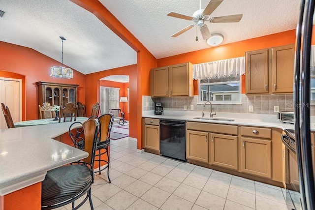 kitchen with lofted ceiling, sink, backsplash, hanging light fixtures, and black appliances