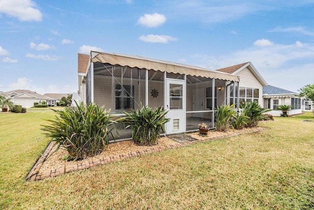 back of house with a sunroom and a yard