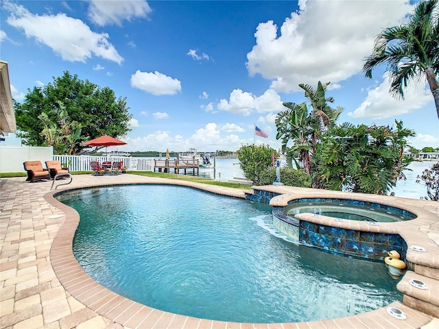 view of pool with an in ground hot tub, a water view, and a patio area