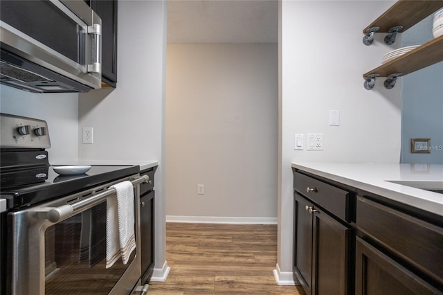 kitchen with stainless steel appliances, wood-type flooring, and dark brown cabinetry