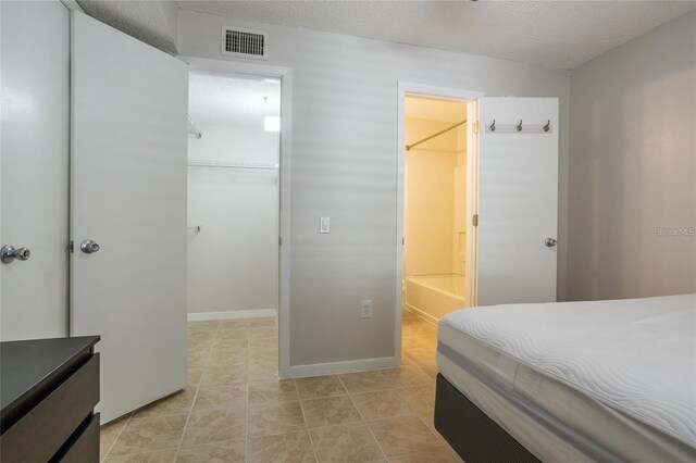 bedroom with a spacious closet, a closet, and a textured ceiling