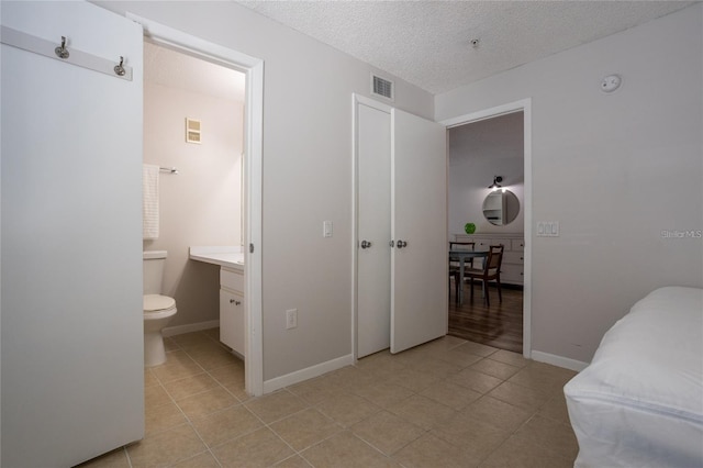 bathroom with vanity, a textured ceiling, tile patterned floors, and toilet