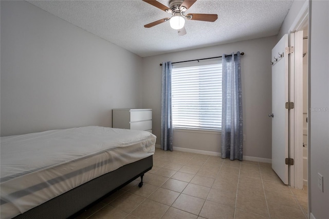 tiled bedroom with a textured ceiling and ceiling fan