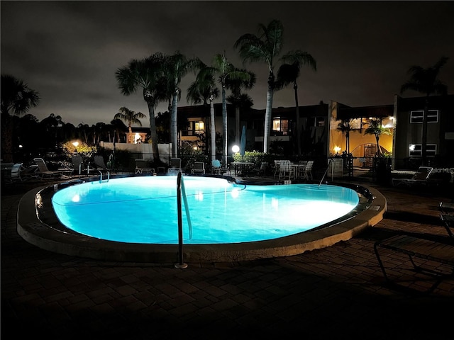 view of pool at twilight