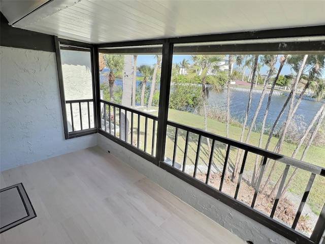 unfurnished sunroom with a healthy amount of sunlight and a water view