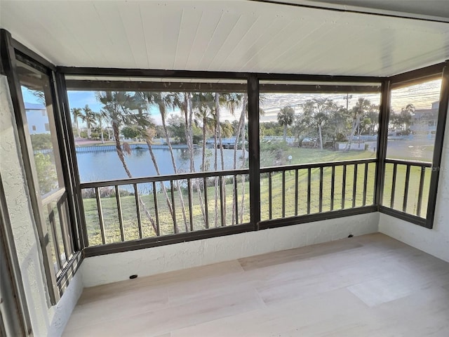 unfurnished sunroom featuring a water view