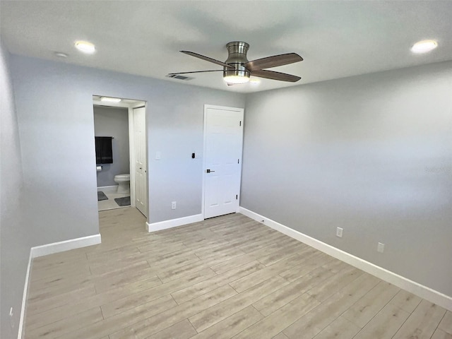 unfurnished bedroom featuring ceiling fan, ensuite bathroom, and light hardwood / wood-style flooring