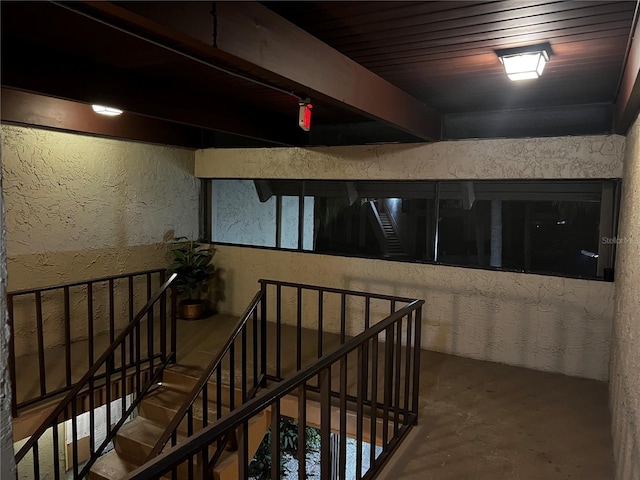 hall featuring concrete flooring and wooden ceiling