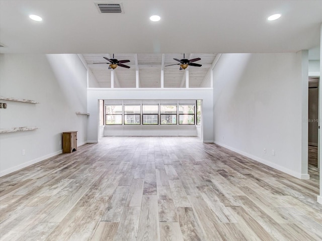 unfurnished living room with high vaulted ceiling, ceiling fan, and light wood-type flooring