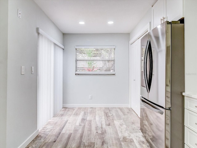 kitchen featuring white cabinetry, light wood-type flooring, and stainless steel refrigerator