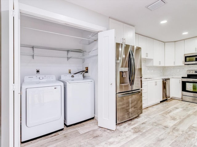 washroom featuring independent washer and dryer and light hardwood / wood-style floors