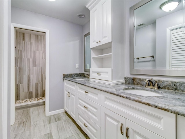 bathroom featuring tiled shower and vanity