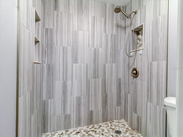 bathroom with tiled shower and toilet