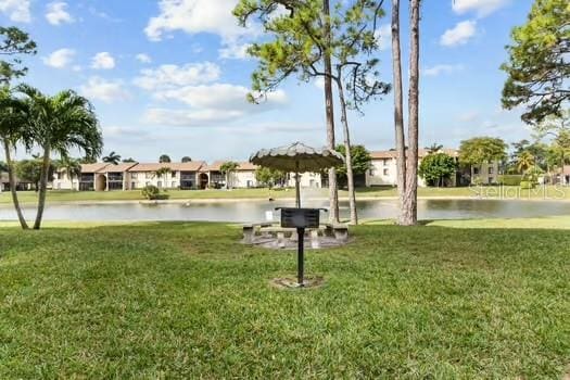 view of property's community with a lawn and a water view