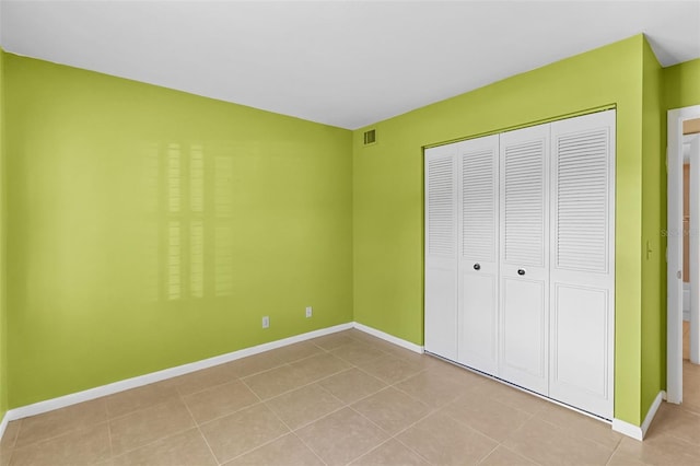 unfurnished bedroom with light tile patterned flooring and a closet