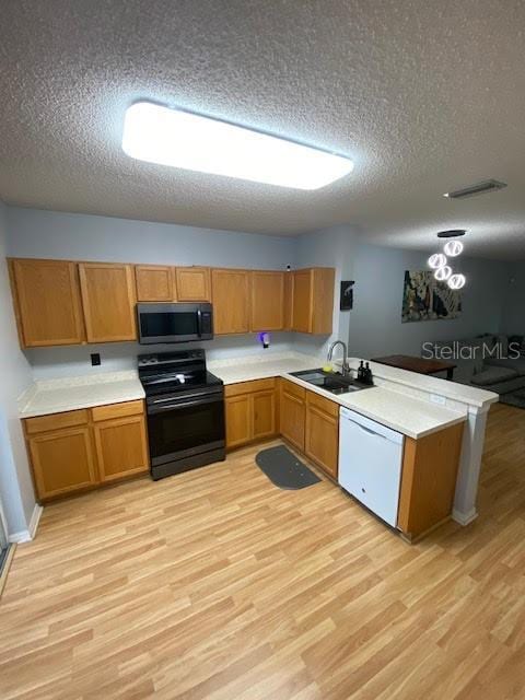 kitchen with white dishwasher, a textured ceiling, black range with electric cooktop, light hardwood / wood-style flooring, and kitchen peninsula