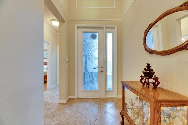 entrance foyer featuring ornamental molding and light tile patterned flooring