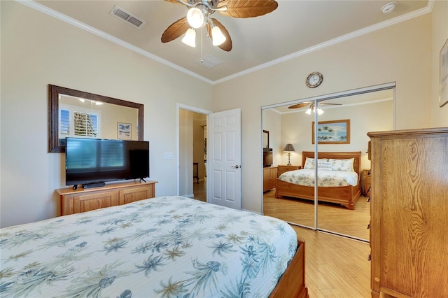 bedroom with crown molding, light wood-type flooring, ceiling fan, and a closet