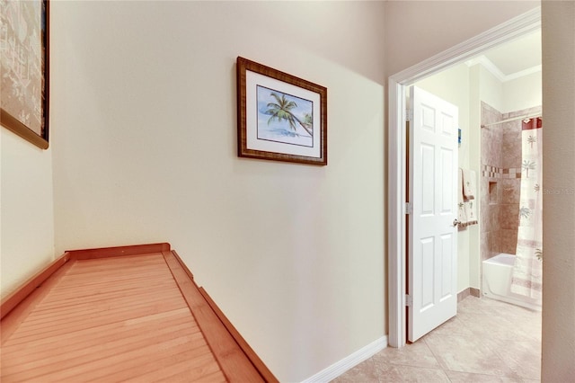 hall with crown molding and light tile patterned floors